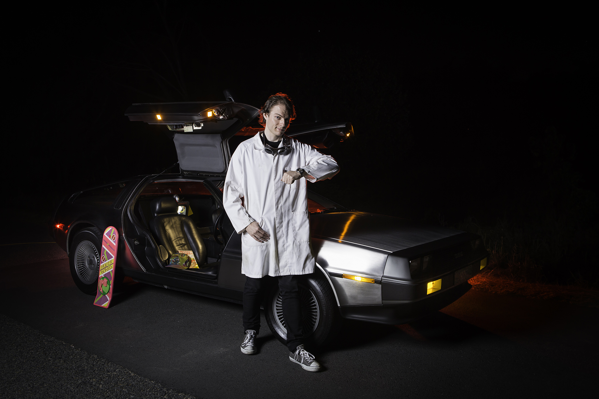 Mike Ando aka riumplus aka RIUM+ standing in front of his DeLorean wearing a labcoat