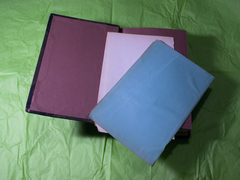 An open book showing a blue page, a white page and a red lining